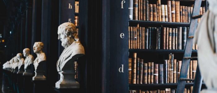 glossary-bg Library with busts and tall bookshelves.
