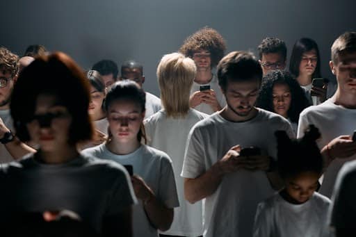 Group of people looking at phones in dim light.